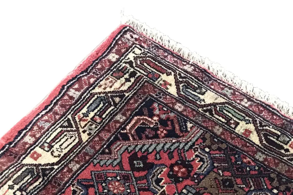 Corner and edge area of a Hamadan rug with fringe, red pattern and beige-blue ornamental motif