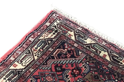 Corner and edge area of a Hamadan rug with fringe, red pattern and beige-blue ornamental motif