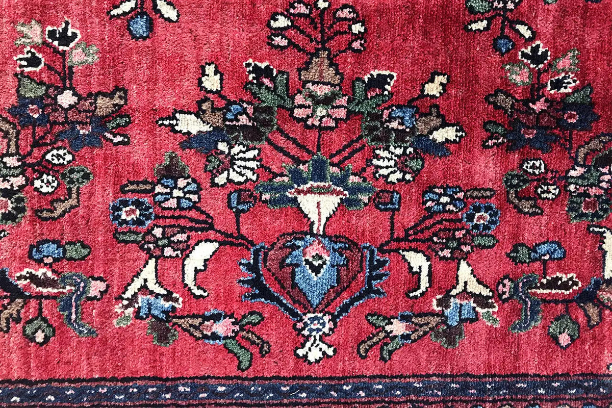 Hamadan rug detail: red field with a central medallion and blue/white ornaments