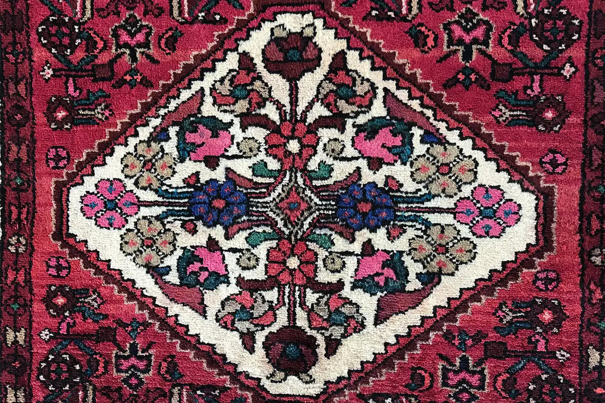 Close-up: red carpet pattern with a white medallion, floral ornaments, and borders