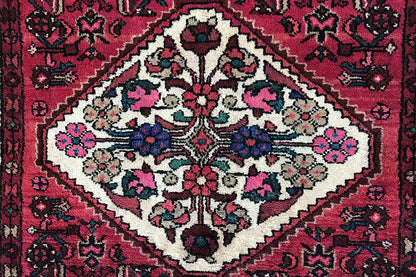 Close-up: red carpet pattern with a white medallion, floral ornaments, and borders