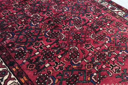 Hamadan runner with a red ground and a dense pattern of vines and small ornaments