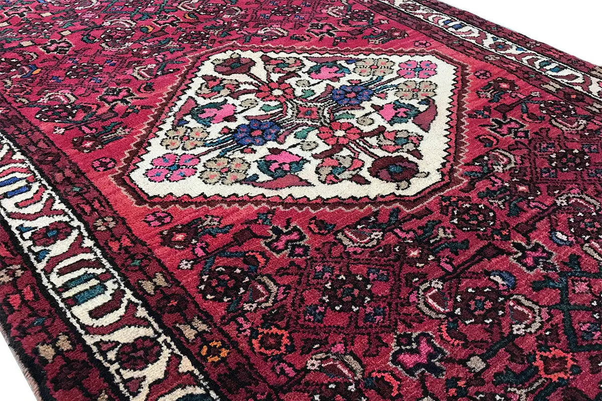 Hamadan runner with a red ground, central white-and-blue medallion, and surrounding border