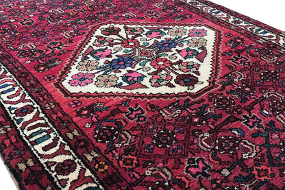 Hamadan runner with a red ground, central white-and-blue medallion, and surrounding border