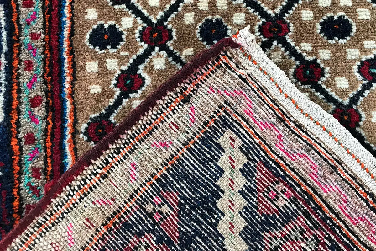 Detail: Fringe-like edge on the beige patterned field with dark blue ornaments