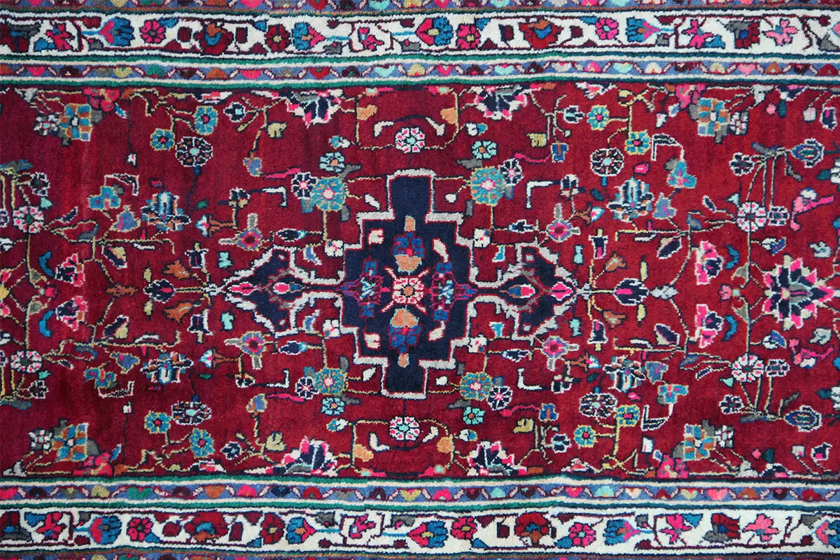 Hamadan runner close-up: red field with blue-green ornamental flowers and a fine pattern