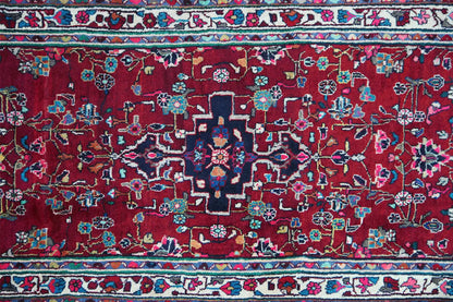 Hamadan runner close-up: red field with blue-green ornamental flowers and a fine pattern