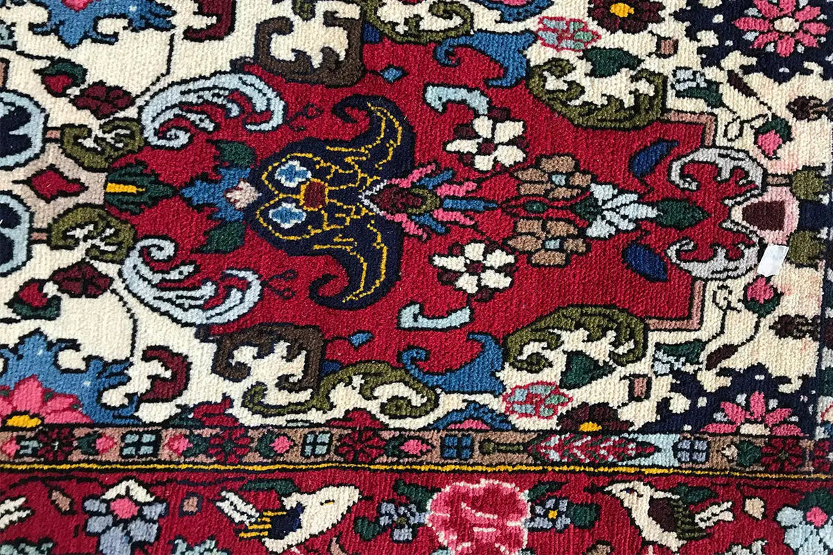 Bakhtiari rug 142x104 cm, detail view: dark floral and vine pattern along the edge