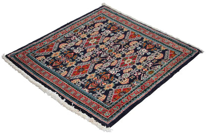 Oriental rug at an angle, dark blue ornamental pattern with a red border and fringes
