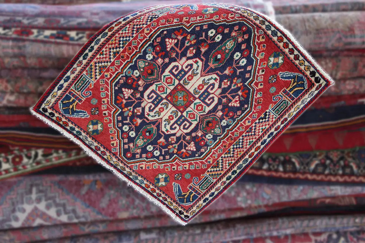 Oriental rug in diamond view: red medallion field with blue ornament and border