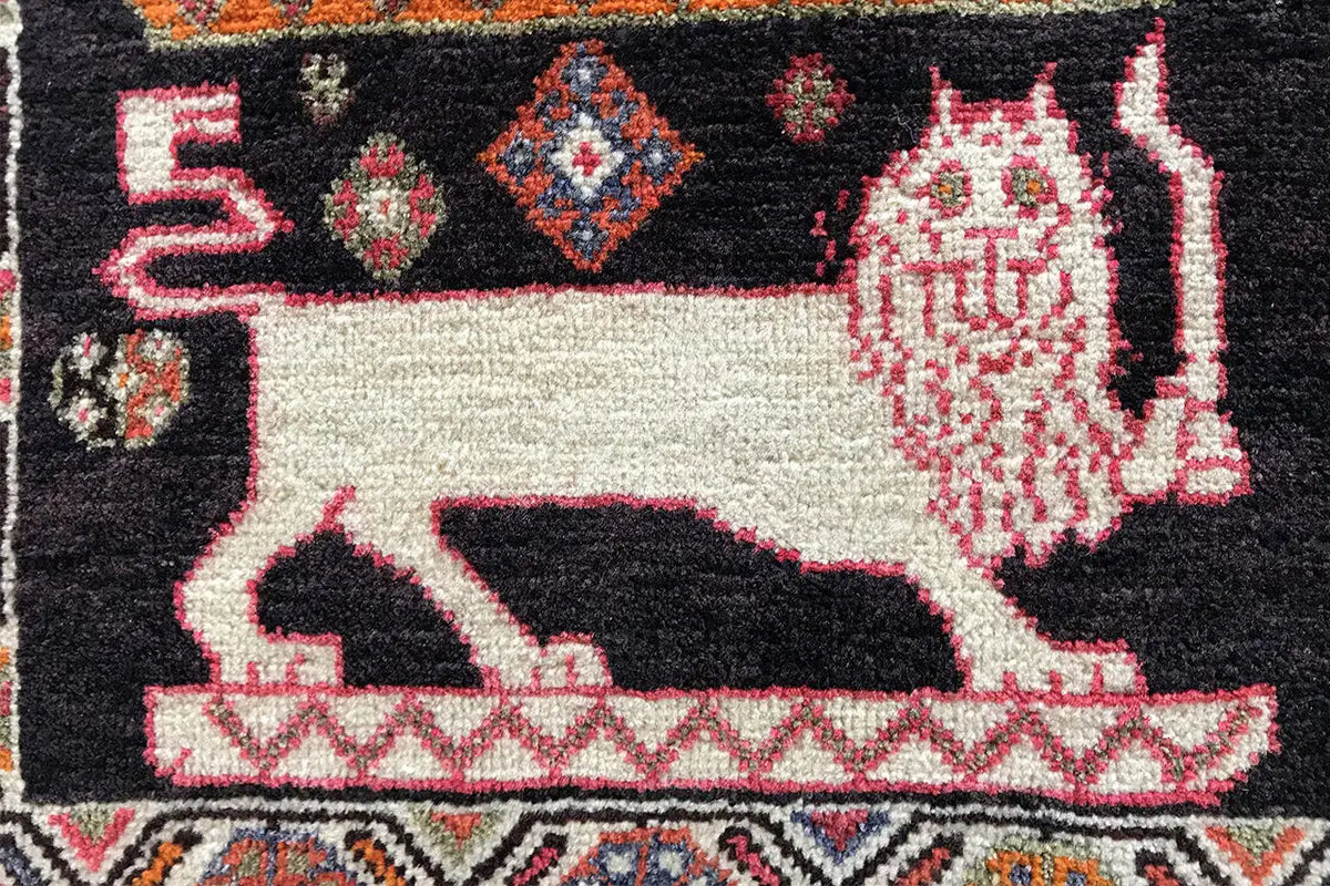 Qashqai carpet details: black field, white animal figure, and red ornaments