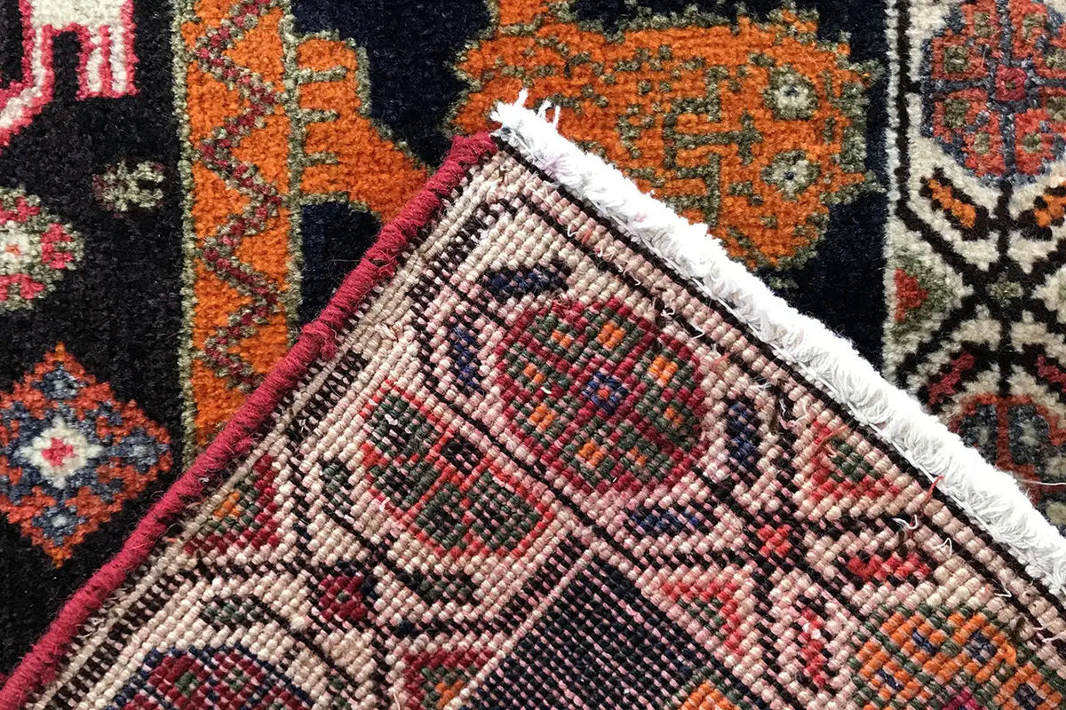 Qashqai rug corner with fringed trim, multicolored patterned border