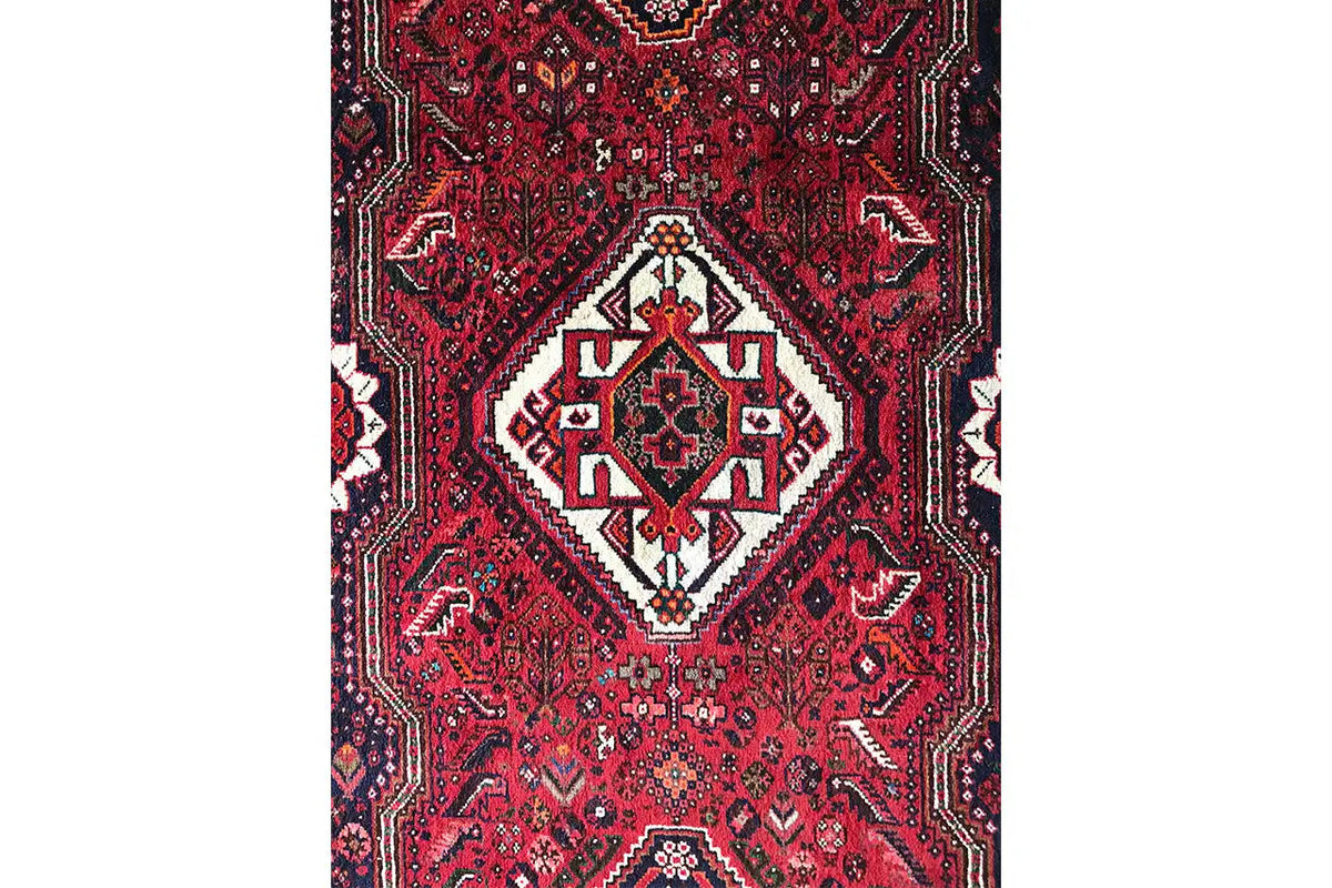 Oriental runner rug with a red background and ornamental patterns in white and dark blue, centered