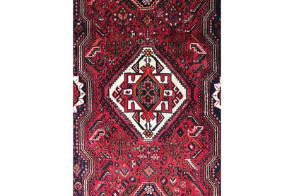 Oriental runner rug with a red background and ornamental patterns in white and dark blue, centered