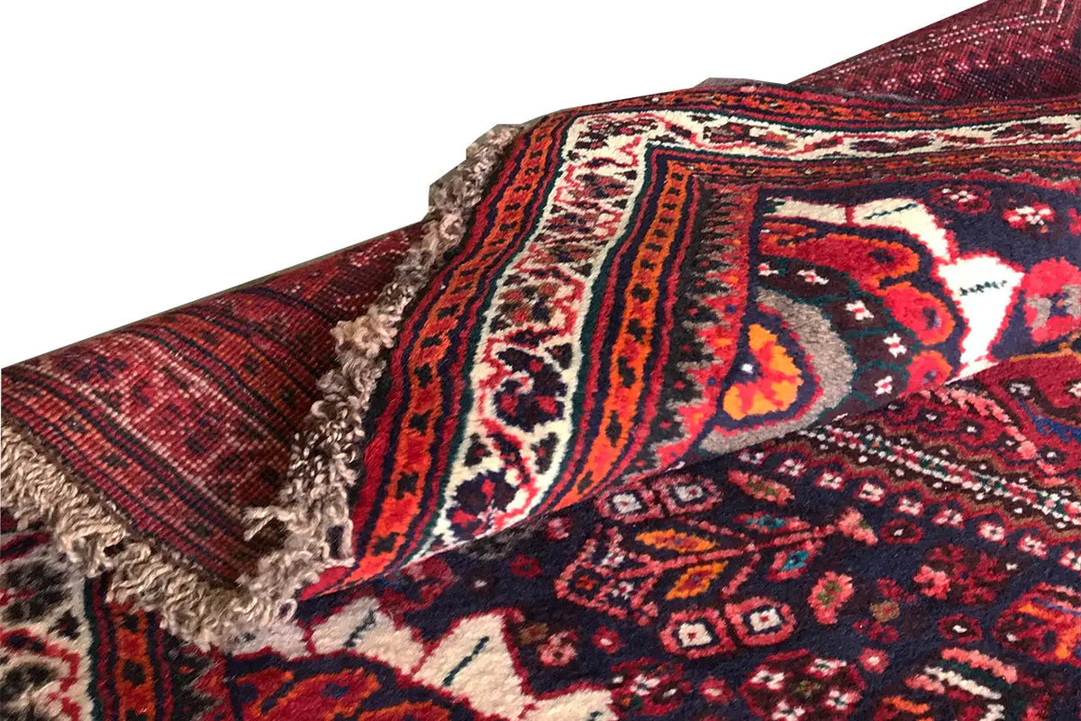 Oriental rug runner with fringe along one edge, red ornamental pattern and border