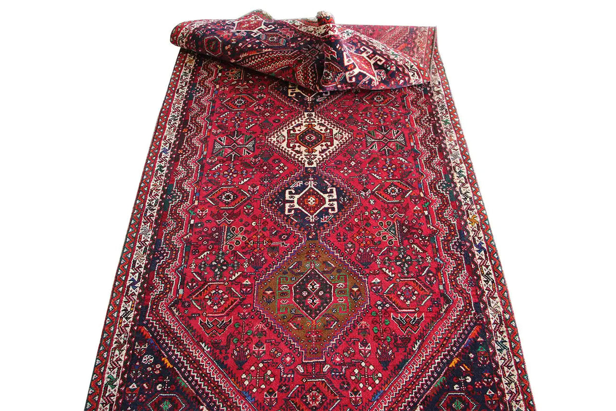 Red runner with ornaments and borders, folded with a visible edge