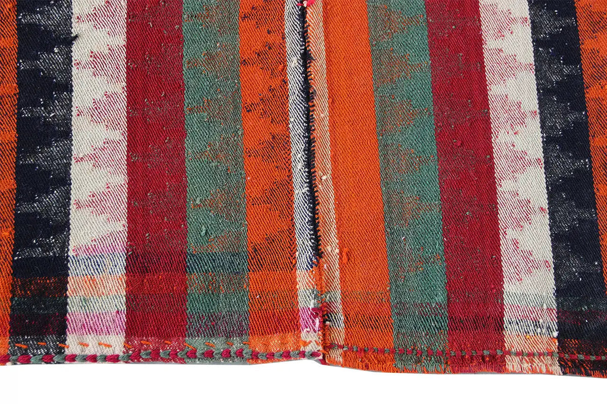 Jajim rug: close-up of the stripes in red, orange, green, and black with fringe.