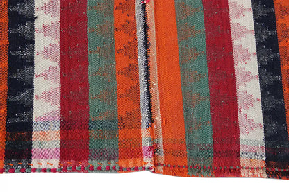 Jajim rug: close-up of the stripes in red, orange, green, and black with fringe.