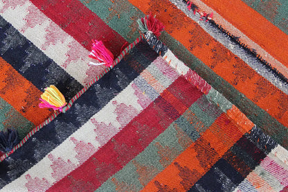 Jajim rug detail with diagonal stripes and shiny threads, tassel along the edge.