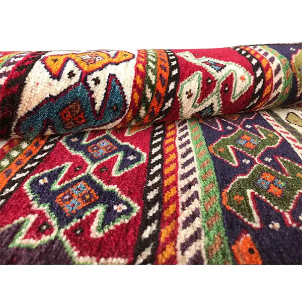 Qashqai rug by Poschti: Detail of the colorful patterns and folded edge along the border