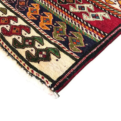 Qashqai rug by Poschti: corner detail with fringes, dark border and geometric motifs