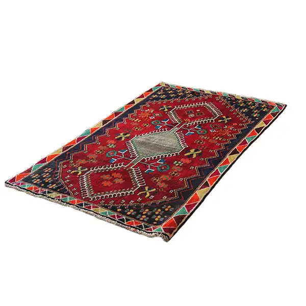 Red and dark blue rug with a symmetrical diamond design and colorful edge border