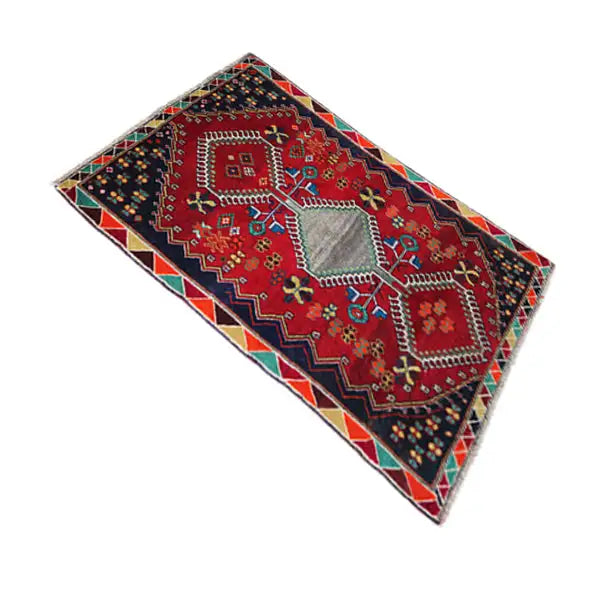 Rug with a red pattern, dark blue background, and multicolored patchwork ornaments