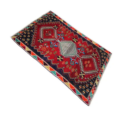 Rug with a red pattern, dark blue background, and multicolored patchwork ornaments