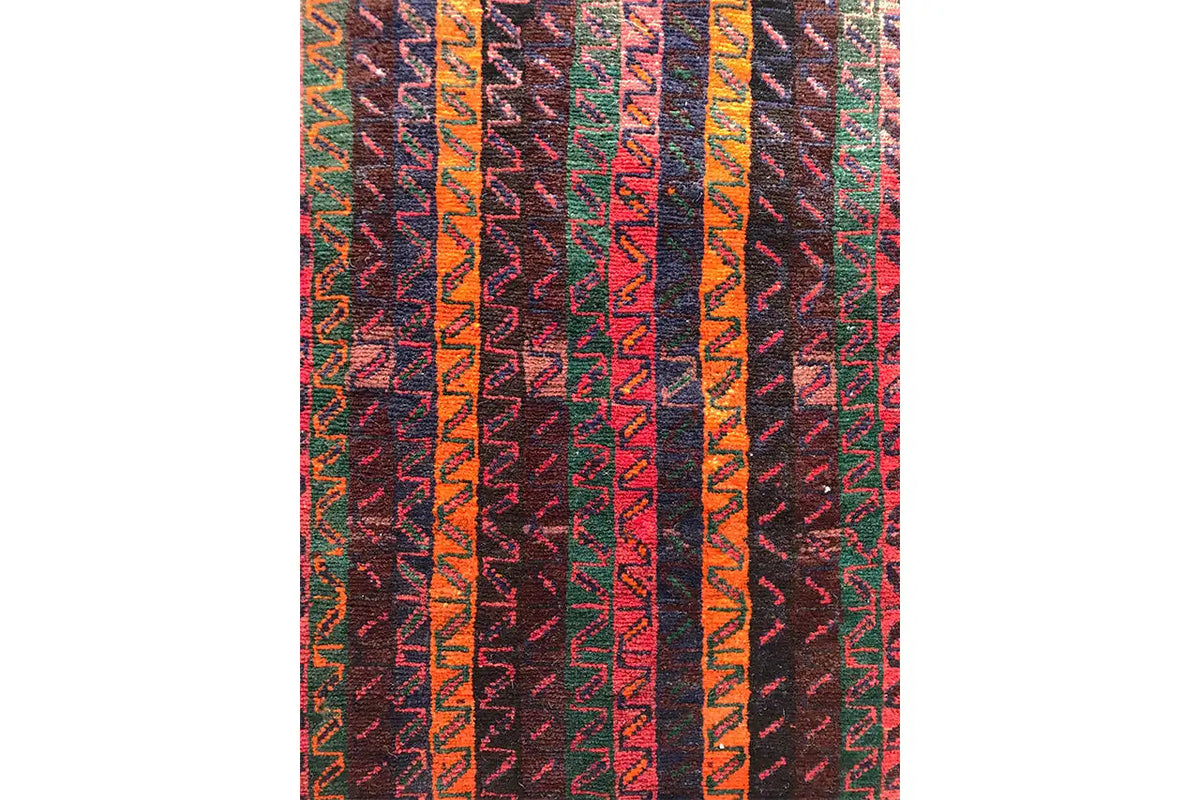 Close-up of a Shiraz Qashqai oriental rug: colorful zigzag stripes in dark red and orange