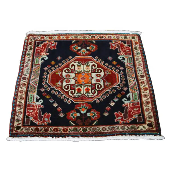 Square oriental rug with a dark blue background, red corners, and a decorative border