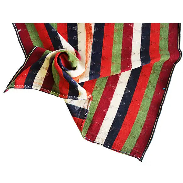 Jajim rug corner made of twisted fabric; red, green, dark blue, and cream-colored stripes.