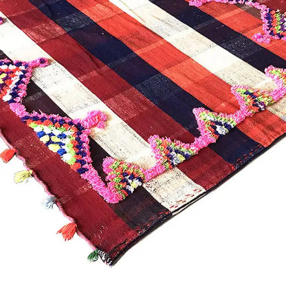 Colorful Jajim rug with a diagonal stripe pattern and colorful decorative tassels along the edge