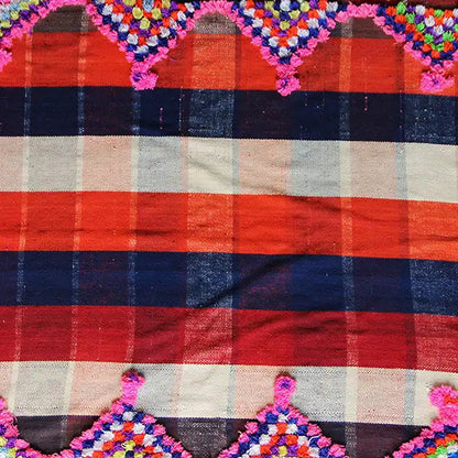 Colorful jajim carpet detail with a checked pattern in red, dark blue, beige, and decorative stitching