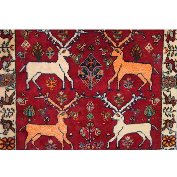 Qashqai rug with a red background, white and yellow animal motifs, and an ornamental border