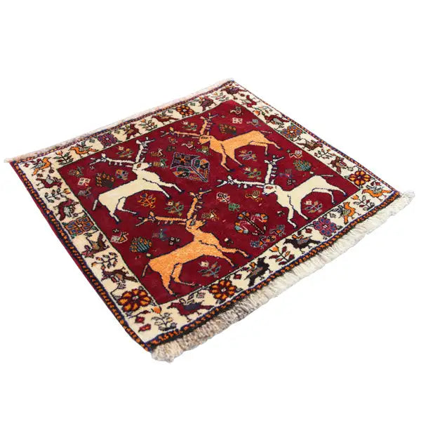 Qashqai rug 61x54 cm with a red central field and animal motifs, angled view