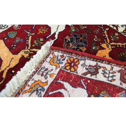 Close-up of the Qashqai carpet edge: fringes and red pattern with animal motifs