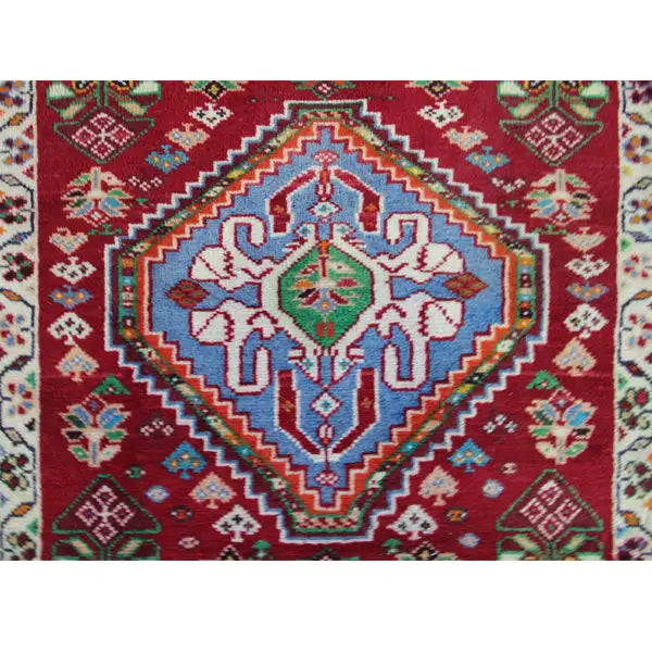 Carpet detail: red field with a blue central ornament and decorative border around the edge