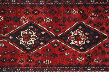 Runner with a large red central medallion, dark blue border pattern, and decorative fringe