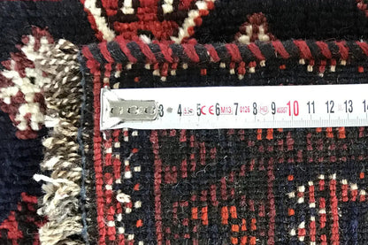 Runner detail: measuring strip along the edge, red-and-black woven pattern with decorative fringes