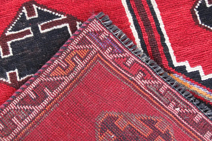 Close-up of Lori rug: red and multicolored pile with fine lines and textured fibers.