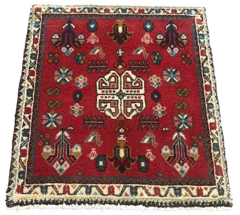 Square red Oriental rug with a central ornamental element and colorful motifs