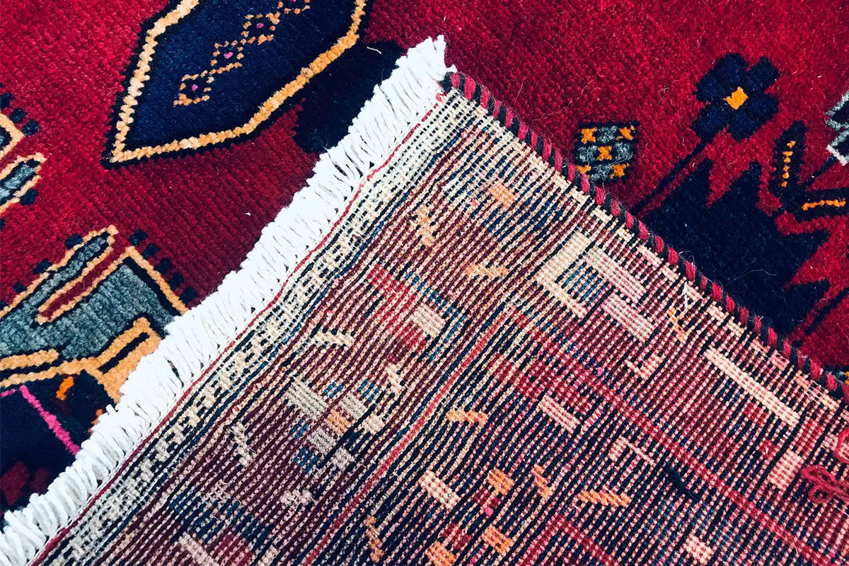 Sirjan carpet: detail of the edge with fringe and a dense red and blue pattern