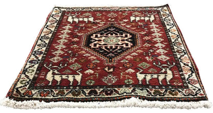 Red rug with a patterned central medallion, multicolored border, and fringe