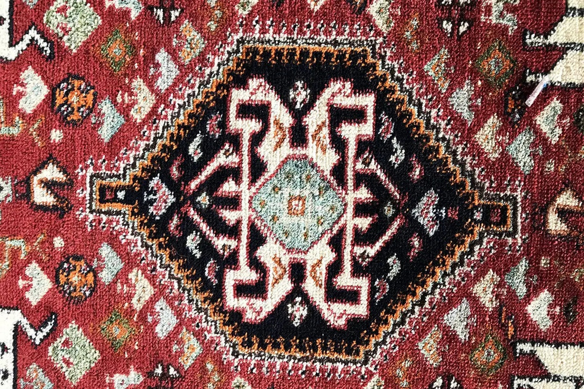 Close-up: red carpet ornament with black trim and white pattern
