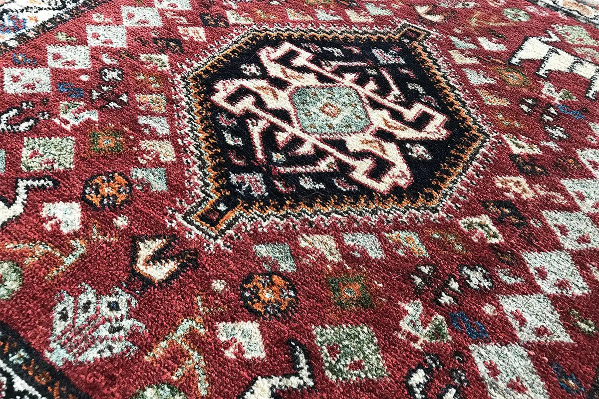 Close-up: red carpet with a dense ornamental pattern and colorful details