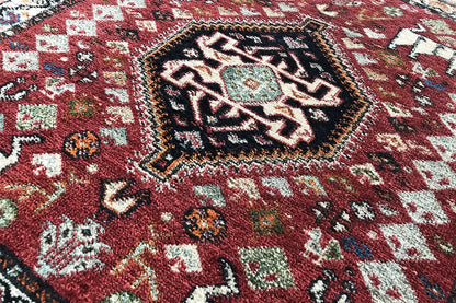 Close-up: red carpet with a dense ornamental pattern and colorful details