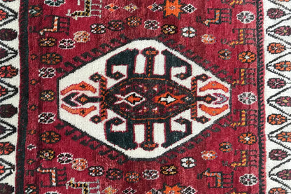 Rug center motif: symmetrical ornaments in red, black, white, and orange