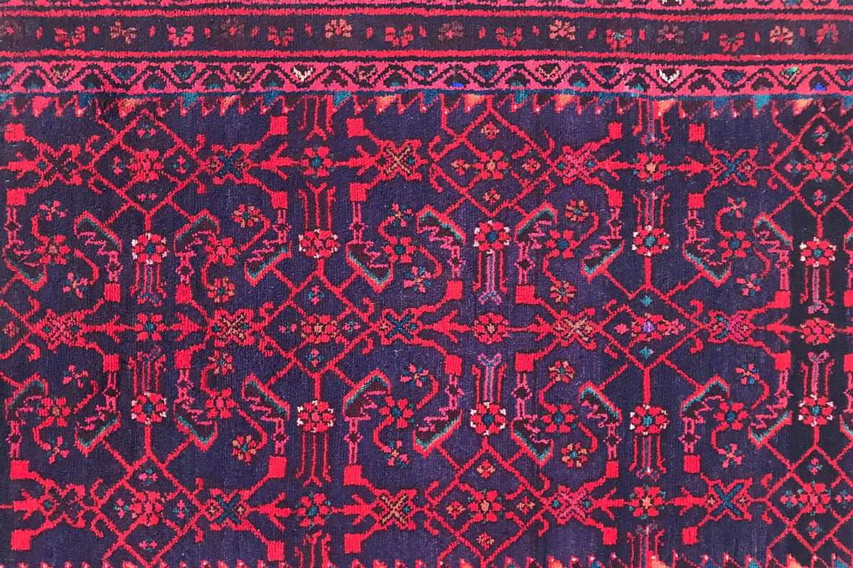 Close-up of a Hamadan runner: burgundy ornamental design on a dark blue background