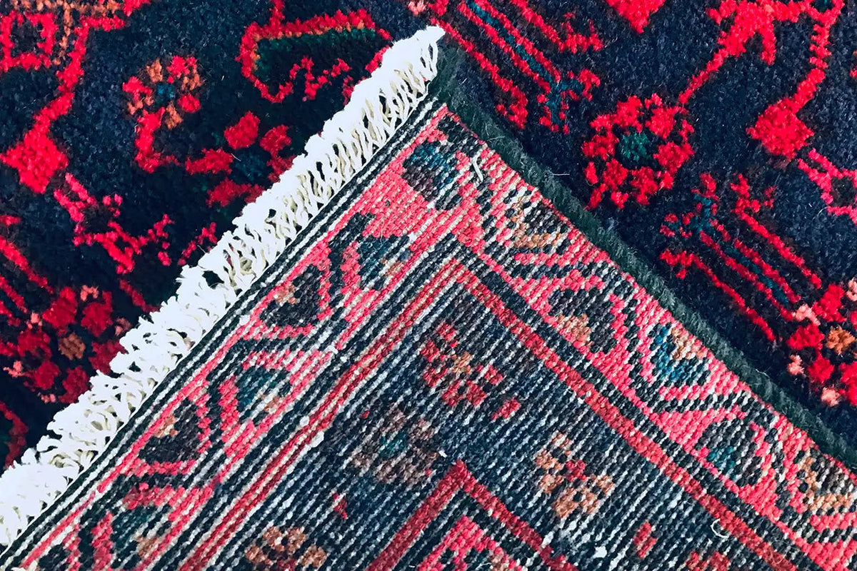 Hamadan runner detail: burgundy vines and geometric border with fringe