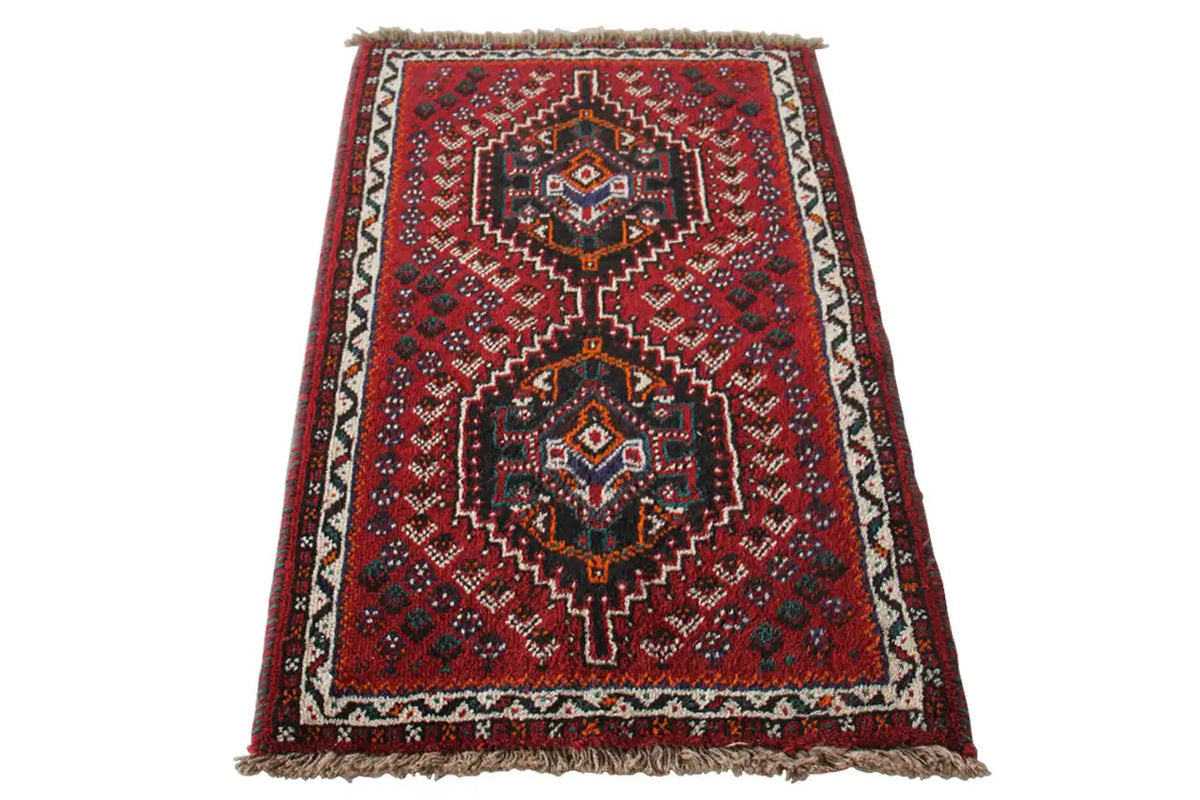 Oriental rug with a red background and geometric pattern, fringes along the edges